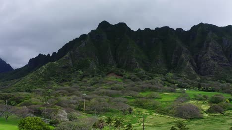 Drone-shot-flying-towards-Kualoa-Ranch's-steep-mountainside-in-Hawaii