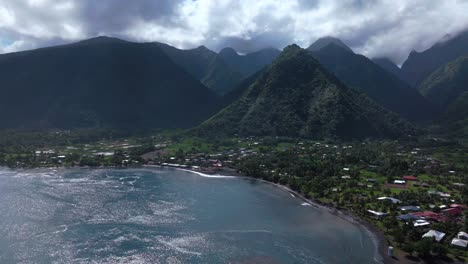 Teahupoo-Tahiti-new-Pedestrian-Bridge-aerial-drone-view-French-Polynesia-bay-coastline-boats-blue-sky-clouds-WSL-Surfing-summer-Olympic-venue-town-village-mountain-peaks-surfer-wave-reef-forward-down