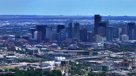 Summer-downtown-Denver-city-skyscrapers-Colorado-aerial-drone-traffic-cars-highway-Mile-High-neighborhood-homes-blue-skies-cloudy-6th-avenue-colfax-RTD-line-front-range-foothills-landscape-pan-right