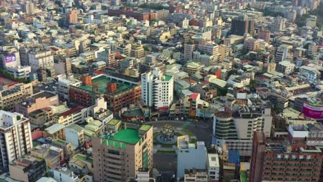 Aerial-birds-eye-view-drone-flyover-downtown-area-capturing-cityscape-featuring-Douliu-Circle,-the-landmark-roundabout-in-the-city-center,-Yunlin-county,-Taiwan