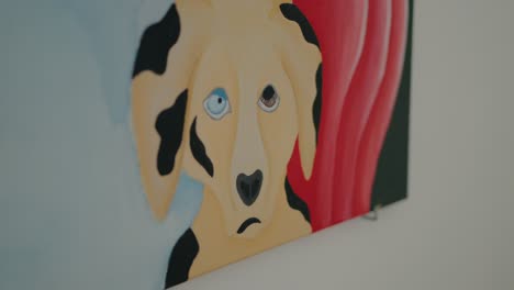 Close-up-of-a-colorful-painting-of-a-dog-with-different-colored-eyes,-showcasing-artistic-expression