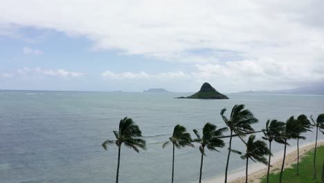 Drone-shot-over-Kauloa-Rock-Beach-in-Hawaii,-China-Man-Hat-Island-in-the-distance