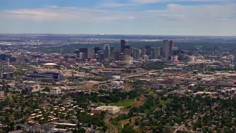 Summer-downtown-Denver-Colorado-aerial-drone-Mile-High-city-skyscrapers-neighborhood-homes-blue-skies-cloudy-6th-avenue-colfax-RTD-line-front-range-foothills-landscape-forward-pan-reveal-motion