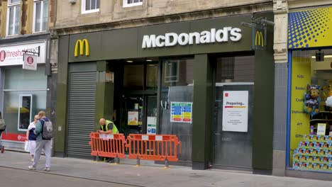 Exterior-of-new-McDonald's-being-prepared-for-opening-with-workers-and-safety-barriers,-Exeter,-Devon,-UK,-July-2024