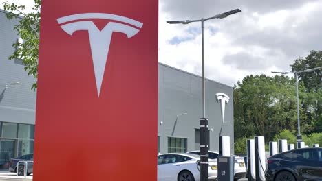 Tesla-Händler-Mit-Auffälligem-Roten-Logo-Schild,-Exeter,-Devon,-Großbritannien,-Juni-2024