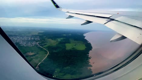 Brazil,-Pará:-Aerial-view-from-inside-an-airplane-over-the-Amazon-River,-showcasing-the-expansive-waters-and-lush-rainforest