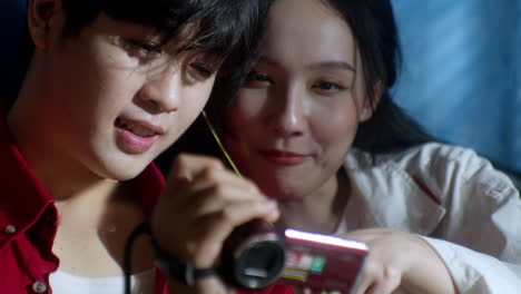 couple-of-asiatic-friends-watching-video-captured-and-record-on-old-vintage-camera-recording