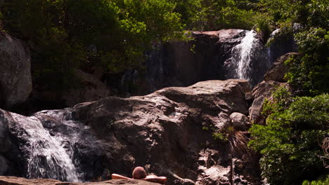 Tourist-Resting,-Relaxing,-Rejuvinating-Under-A-Waterfall-Jungle-Paradise-In-Southeast-Asia,-Vietnam