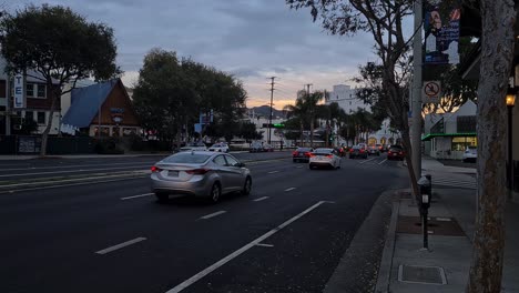 Los-Angeles,-Kalifornien,-USA,-Verkehr-Auf-Dem-Sunset-Boulevard-In-West-Hollywood-In-Der-Dämmerung,-Blick-Auf-Den-Bürgersteig