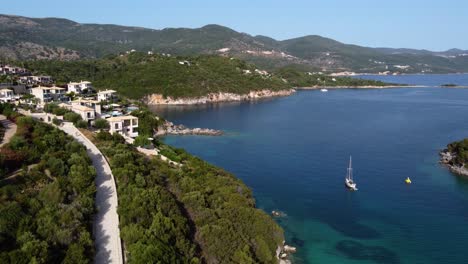 Aerial-Revealing-Down-of-Syvota-Coastal-Bay-and-Anchored-Sailing-Boat