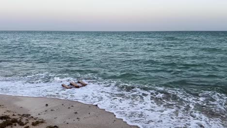 Die-Malerische-Aussicht-Auf-Eine-Starke-Meereswelle,-Die-Gegen-Einen-Sandstrand-Aus-Holzpaletten-Kracht,-Ein-Zuhause-Mit-Karettschildkröte,-Die-Natürliche-Szene-Unterstreicht-Die-Bedeutung-Der-Bewahrung-Mariner-Lebensräume-Und-Des-Schutzes-Bedrohter-Arten-In-Den-Vereinigten-Arabischen-Emiraten