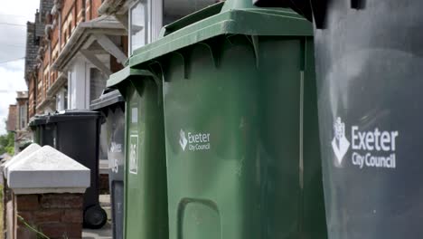 Many-bins-outside-student-accommodation-with-brick-buildings-in-background,-Exeter,-Devon,-UK,-June-2024