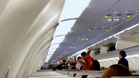 Interior-panorama-of-an-airplane-with-passengers-boarding-and-storing-luggage