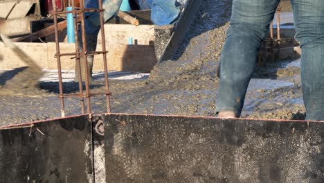 Lone-construction-worker-levelling-the-newly-poured-cement-mixture-on-the-flooring-of-a-building-under-construction-in-the-outskirts-of-Bangkok,-Thailand