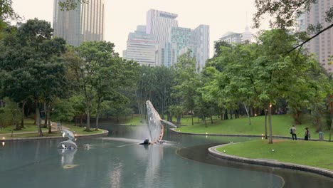 Whale-statute-and-pond-at-Suria-KLCC-Park,-Kuala-Lumpur,-Malaysia-during-the-evening