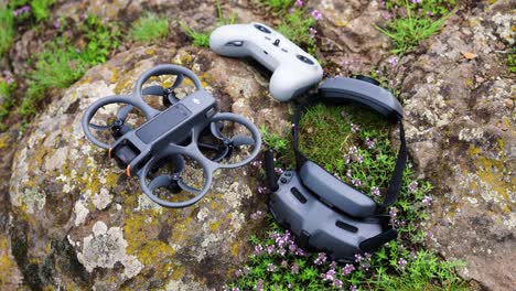 High-angle-view-of-compact-FPV-drone-aircraft,-goggles-and-remote-control