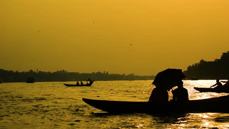 Silhouette-Von-Hölzernen-Kanubooten-Auf-Dem-Buriganga-Fluss-Im-Sonnenuntergang,-Die-Passagiere-In-Bangladesch-Befördern