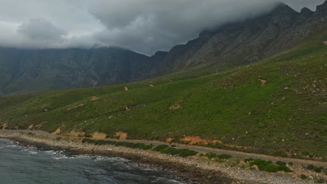 Car-driving-down-a-scenic-coastal-road-near-Cape-Town