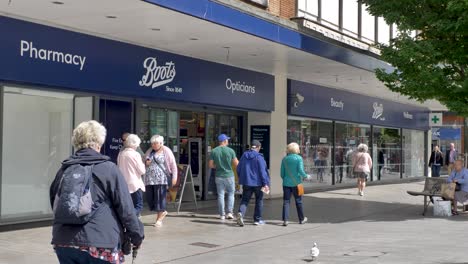 Exterior-of-large-Boots-shop-facade-with-customers-entering-and-exiting,-Exeter-Devon-UK,-June-2024