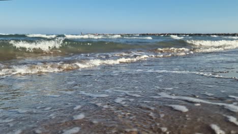 Close-up-of-ocean-waves-breaking-on-the-shore-of-the-beach