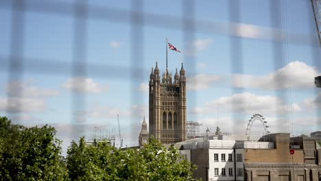 Londons-Stadtbild-Mit-Dem-Hoch-Aufragenden-Big-Ben,-Dem-Historischen-Westminster-Palace,-Dem-Modernen-London-Eye-Und-Einem-Klaren-Blauen-Himmel-Mit-Einer-Union-Jack-Flagge