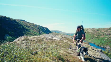 Active-Caucasian-Guy-With-Backpack-And-Dog-Over-Mountain-Trails