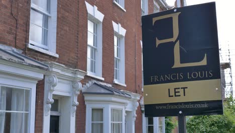 LET-estate-agent-sign-outside-of-terraced-red-brick-house,-Exeter,-Devon,-UK,-June-2024