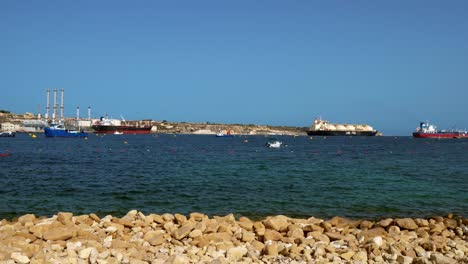 Delimara-Power-Station-with-awaiting-LNG-tanker-and-other-industrial-ships-on-the-Mediterranean-Sea-in-Marsaxlokk,-Malta