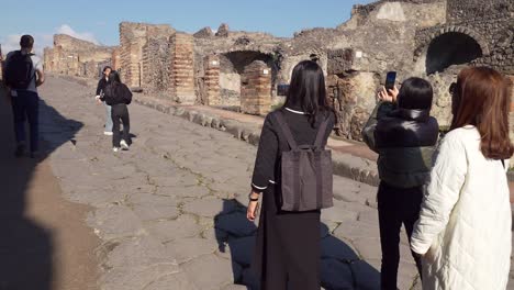 Gente-Asiática-Tomando-Fotografías-En-La-Famosa-Ciudad-Antigua-De-Pompeya-Con-Un-Auténtico-Sendero-Y-Ruinas---Nápoles,-Italia