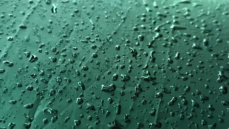 Rain-drops-on-black-umbrella,-rain-droplets-stuck-on-umbrella-create-a-beautiful-texture