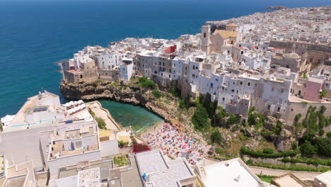 Town-And-The-Lama-Monachile-Beach-In-Polignano-a-Mare,-Apulia-Region,-Italy---Aerial-Drone-Shot