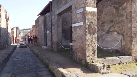 People-walking-in-the-famous-ancient-city-of-Pompeii-with-authentic-footpath-road-and-ruins---Naples,-Italy