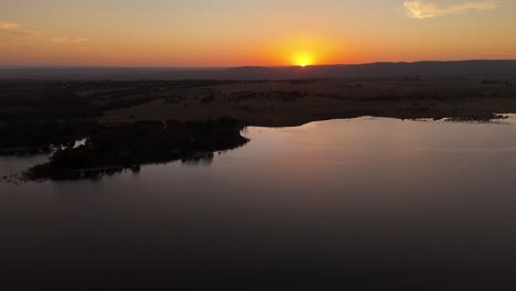 Panorama-Aéreo-Que-Muestra-Un-Lago-Tranquilo-En-El-Embalse-De-Merremi-Durante-La-Puesta-De-Sol-Dorada