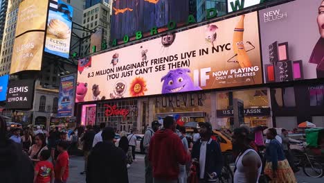 Una-Atmósfera-Vibrante-De-Times-Square-Bajo-Un-Cielo-Despejado,-En-La-Ciudad-De-Nueva-York,-Con-La-Cámara-Girando-Aproximadamente-100-Grados-Hacia-La-Derecha-Para-Revelar-Varios-Carteles-Publicitarios.