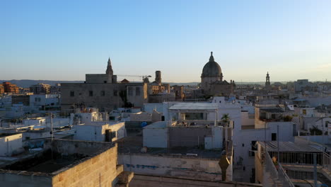 Rotating-drone-shot-of-Polignano-a-Mare-at-sunset-in-Puglia,-Italy