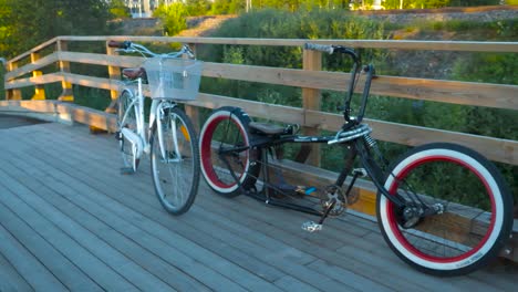 Imágenes-En-Movimiento-Lento-De-Dos-Bicicletas-O-Bicicletas-En-Un-Viejo-Puente-De-Madera-Sobre-Un-Pequeño-Río-Rural