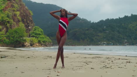 In-Trinidad-and-Tobago,-a-young-African-girl-in-a-bikini-spends-her-day-at-the-beach-with-ocean-waves-in-the-background