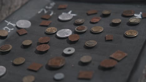 Close-up-of-unique-coins-displayed-on-a-tray-at-Varaždin's-Market-of-Traditional-Crafts