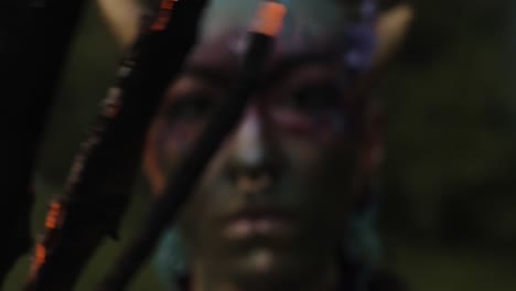 Closeup-of-a-fire-Mystical-performer-in-tribal-face-paint,-holding-a-flaming-burning-stick