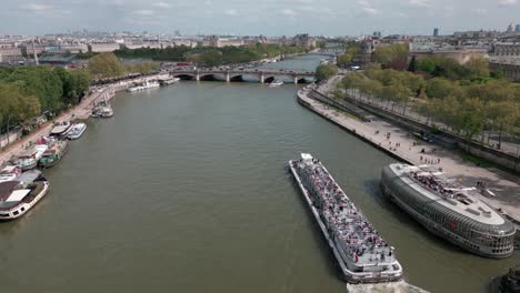 Boats-navigating-along-Seine-River-with-Paris-cityscape-in-background,-France