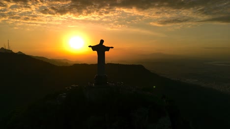 Atemberaubende-Luftaufnahmen-Der-Christusstatue-In-Rio-De-Janeiro-Vor-Der-Kulisse-Eines-Atemberaubenden-Sonnenuntergangs,-Die-Die-Ruhige-Schönheit-Und-Ikonische-Präsenz-Dieses-Monumentalen-Wahrzeichens-Einfangen