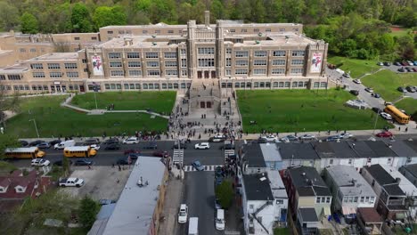 High-school-building-in-Reading,-Pennsylvania-with-students-and-school-buses-in-front