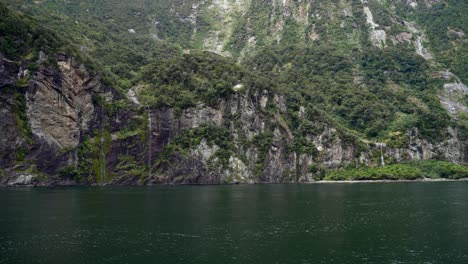 Milford-Sound-view-from-a-cruise-deck-with-fiords-and-waterfalls-in-sight