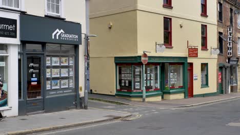 Exterior-view-of-estate-agent-windows-displaying-property-listings-in-urban-setting,-Exeter-Devon-UK,-June-2024