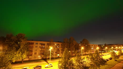 Luces-Brillantes-De-La-Ciudad-Y-Aurora-Boreal-Arriba,-Lapso-De-Tiempo