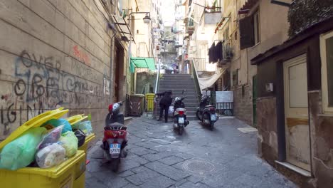 Waste-bin-containers-full-of-trash-in-the-city-street-of-Quartieri-Spagnoli-in-Naples,-Italy