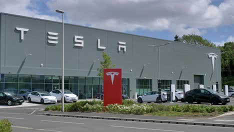 Concesionario-Tesla-Con-Muchos-Coches-Estacionados-Afuera-En-Unas-Instalaciones-Modernas,-Exeter,-Devon,-Reino-Unido,-Junio-De-2024