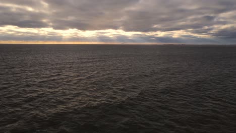 Sunset-light-and-dramatic-clouds-over-Lake-Erie-near-Luna-Pier-Michigan,-USA---one-of-the-Great-Lakes