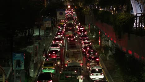 Busy-traffic-jam-in-the-city-of-Bangkok-at-night,-cars-are-driving-very-slowly-with-lots-of-red-car-lights