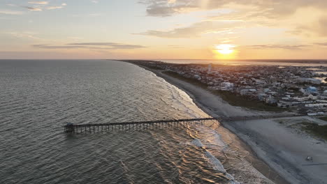 Epic-drone-shot-of-sun-setting-over-Atlantic-Beach-North-Carolina,-panning-aerial-shot